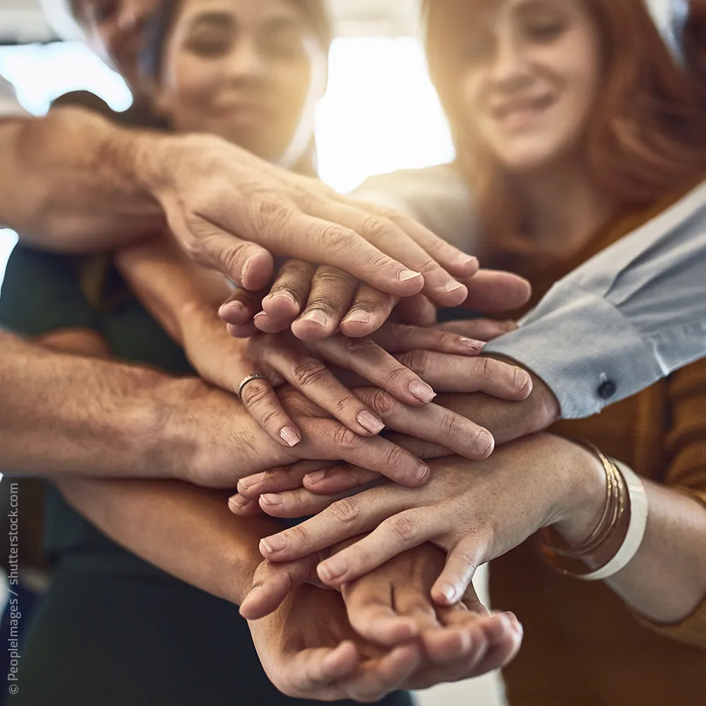 Team mit übereinander gelegten Händen